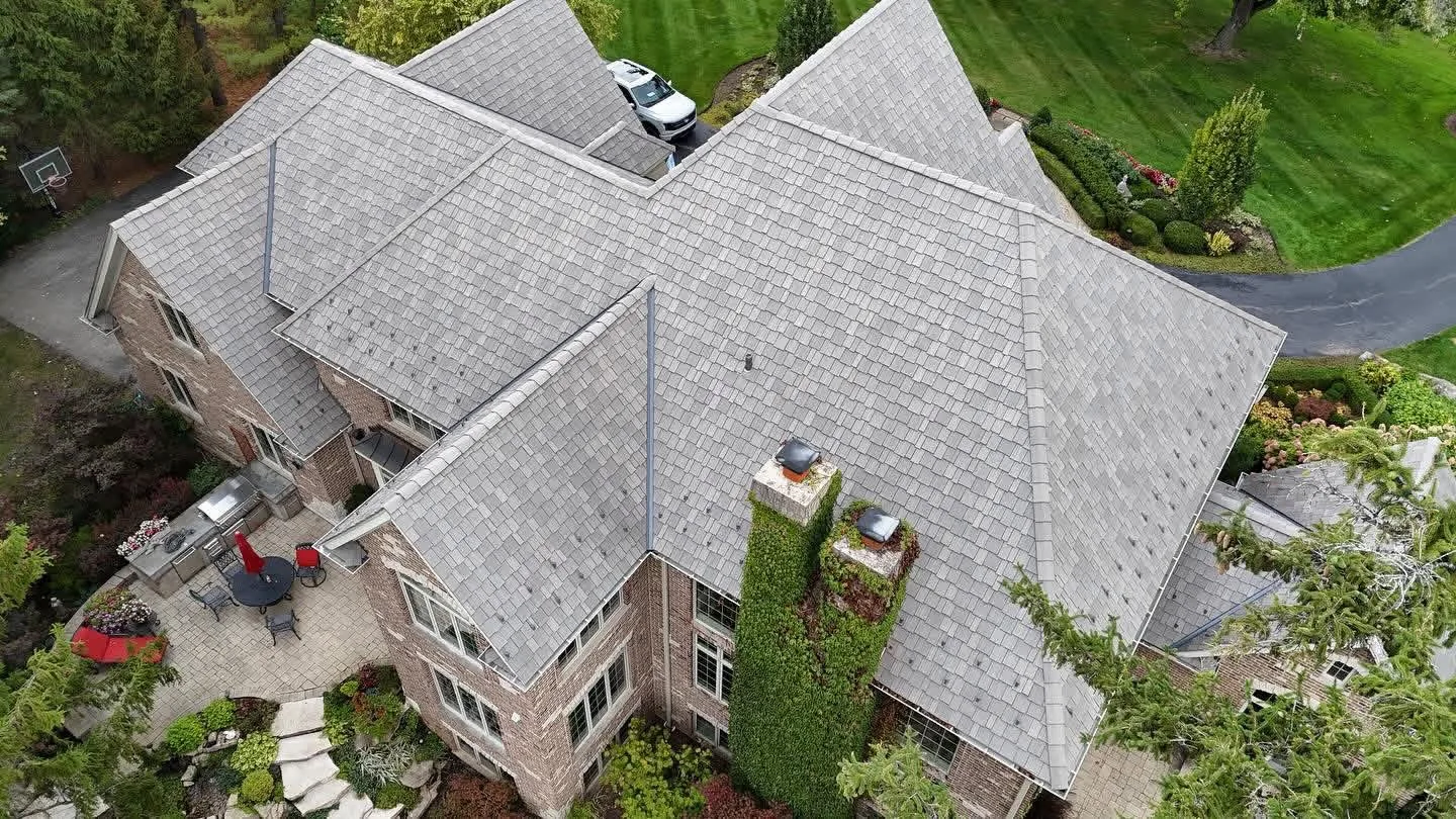 Finished grey designer shingle roof on a large brick home in the Chicago suburbs